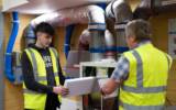 South West College construction and trades student with lecturer in workshop wearing high-vis jackets