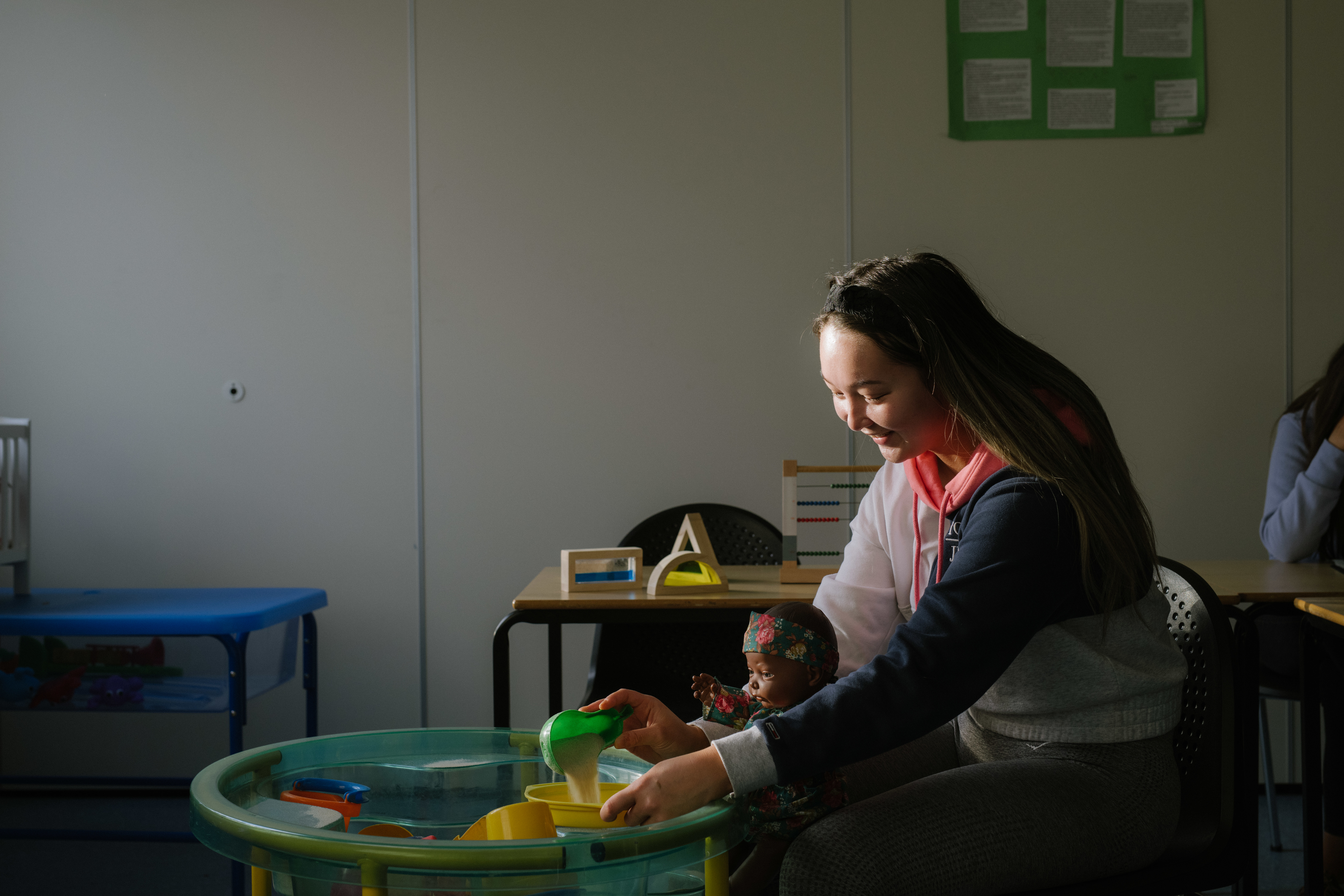 Student sitting in childcare setting at sand tray