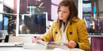 Female SWC student reading in bright modern campus library